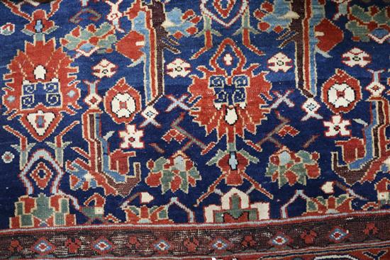 A Kazak style blue ground rug, woven with stylised flowerheads, 224cm x 135cm